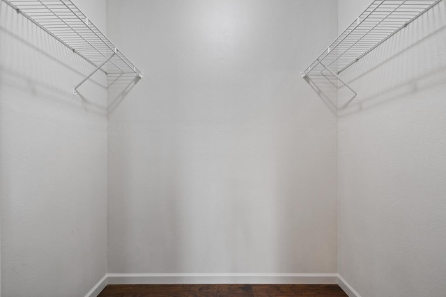 walk in closet with wood finished floors