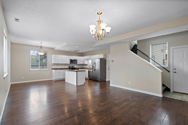kitchen featuring stainless steel appliances, a chandelier, open floor plan, white cabinets, and dark wood-type flooring