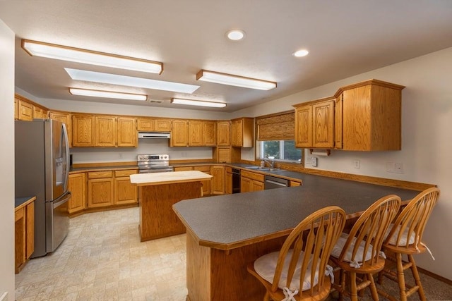 4414 Garden Spot Rd, Clayton, WA 99110 - kitchen with stainless steel appliances, a peninsula, a sink, a kitchen island, and a kitchen breakfast bar