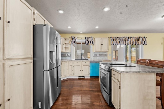 5612 N Vista Grande Dr, Otis Orchards, WA 99027 - kitchen with appliances with stainless steel finishes, a textured ceiling, dark wood-type flooring, a breakfast bar area, and recessed lighting