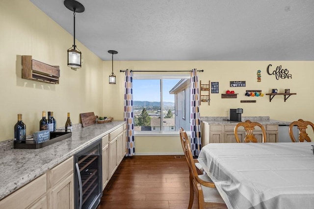 5612 N Vista Grande Dr, Otis Orchards, WA 99027 - dining room with wine cooler, a dry bar, dark wood-style flooring, a textured ceiling, and baseboards