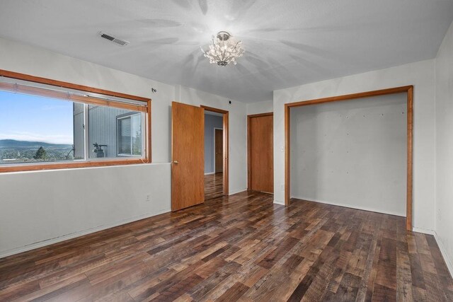 5612 N Vista Grande Dr, Otis Orchards, WA 99027 - unfurnished bedroom with a chandelier, wood finished floors, a closet, and baseboards