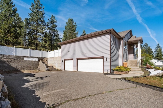 5612 N Vista Grande Dr, Otis Orchards, WA 99027 - view of side of property featuring an attached garage, asphalt driveway, and fence