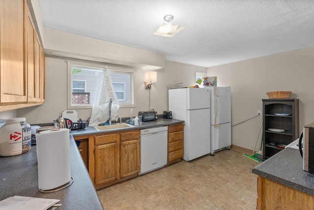 2124 N Dakota St, Spokane, WA 99207 - kitchen with white appliances, brown cabinets, dark countertops, a sink, and a textured ceiling