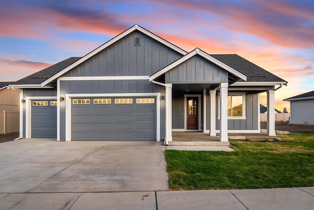 5741 S Sherri Lea Rd, Spokane, WA 99224 - view of front of home featuring a garage, driveway, a porch, a yard, and a shingled roof