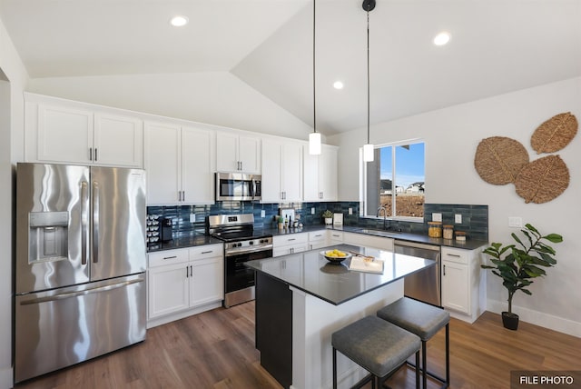 5741 S Sherri Lea Rd, Spokane, WA 99224 - kitchen featuring stainless steel appliances, a sink, dark countertops, vaulted ceiling, and dark wood finished floors