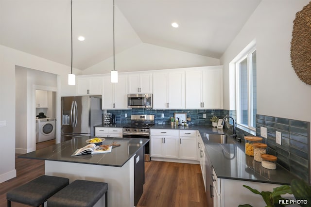 5741 S Sherri Lea Rd, Spokane, WA 99224 - kitchen featuring washer / clothes dryer, stainless steel appliances, a sink, dark countertops, and dark wood-style floors