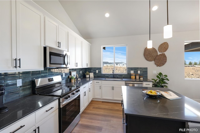 5741 S Sherri Lea Rd, Spokane, WA 99224 - kitchen with stainless steel appliances, a sink, lofted ceiling, backsplash, and white cabinets