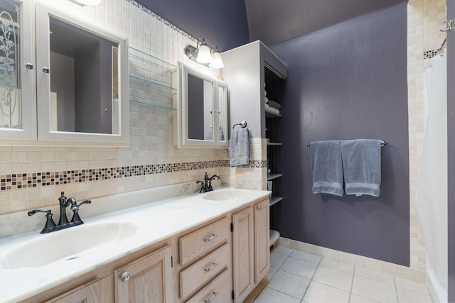bathroom featuring tile patterned floors, double vanity, and baseboards