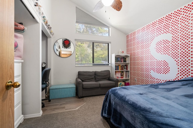 carpeted bedroom with lofted ceiling, an accent wall, ceiling fan, and baseboards