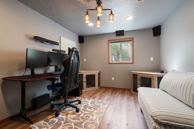 office featuring wood finished floors, baseboards, and a textured ceiling
