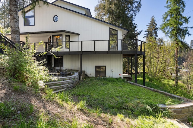 back of house featuring a wooden deck and a yard