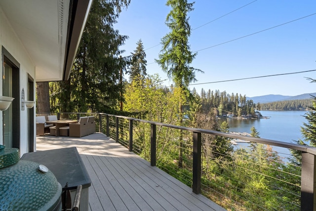 wooden deck featuring outdoor lounge area and a water and mountain view
