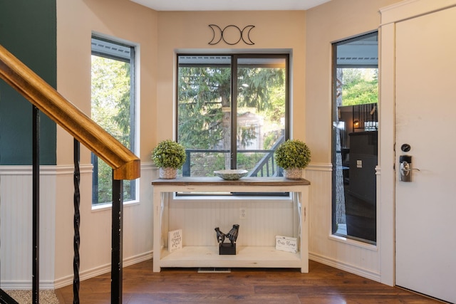 doorway to outside featuring wood finished floors and a wainscoted wall
