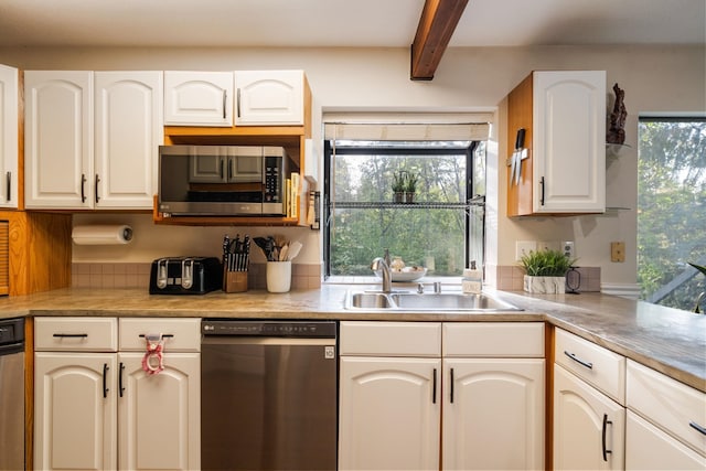 kitchen with dishwashing machine, a sink, stainless steel microwave, beamed ceiling, and plenty of natural light