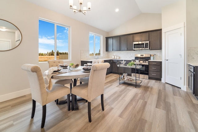 5763 S Sherri Lea Rd, Spokane, WA 99224 - dining area with a chandelier, light wood finished floors, high vaulted ceiling, and baseboards