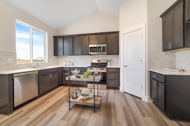 5763 S Sherri Lea Rd, Spokane, WA 99224 - kitchen featuring appliances with stainless steel finishes, a sink, light wood finished floors, decorative backsplash, and light countertops