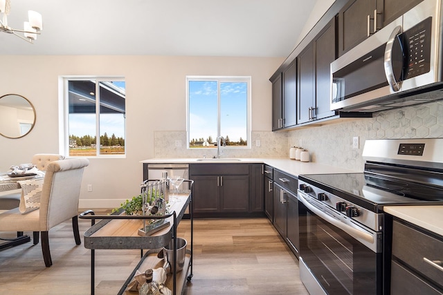 5763 S Sherri Lea Rd, Spokane, WA 99224 - kitchen with stainless steel appliances, a sink, light wood-style flooring, and light countertops