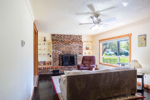 211 4th St, Dover, ID 83825 - living room with a textured ceiling, hardwood / wood-style floors, a fireplace, ceiling fan, and ornamental molding