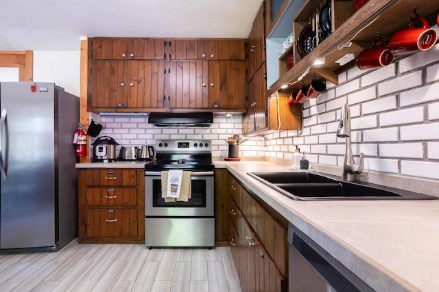 211 4th St, Dover, ID 83825 - kitchen with appliances with stainless steel finishes, extractor fan, a sink, brown cabinetry, and backsplash