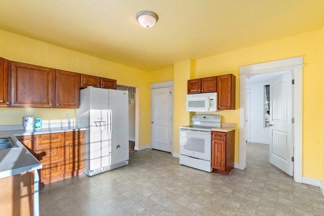 217 S Broadway St, Tekoa, WA 99033 - kitchen with white appliances, baseboards, brown cabinets, and light countertops