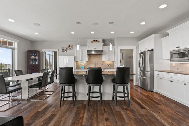 8504 E Black Oak Ln, Spokane, WA 99217 - kitchen featuring appliances with stainless steel finishes, under cabinet range hood, tasteful backsplash, white cabinets, and recessed lighting