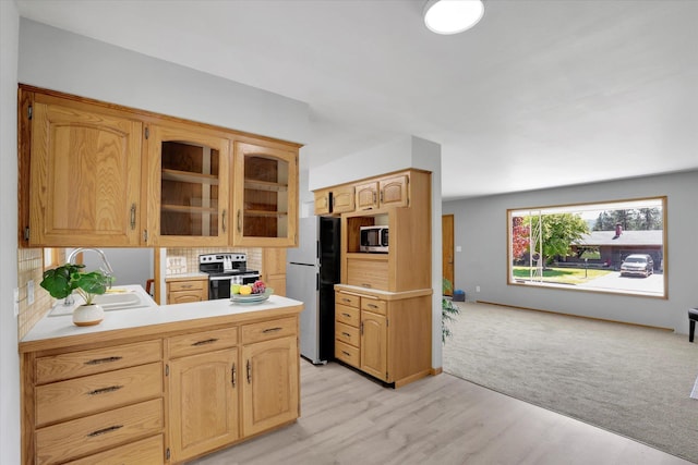 13519 E 26th Ave, Spokane, WA 99216 - kitchen with appliances with stainless steel finishes, a sink, glass insert cabinets, light countertops, and light wood-type flooring