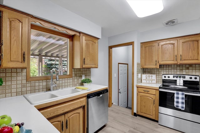 13519 E 26th Ave, Spokane, WA 99216 - kitchen featuring stainless steel appliances, a sink, light countertops, and tasteful backsplash