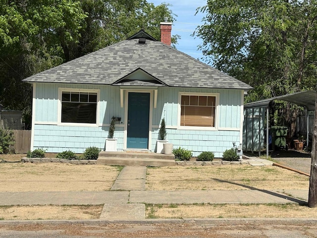 1711 E 14th Ave, Spokane, WA 99202 - bungalow-style house featuring roof with shingles, a chimney, fence, and a detached carport