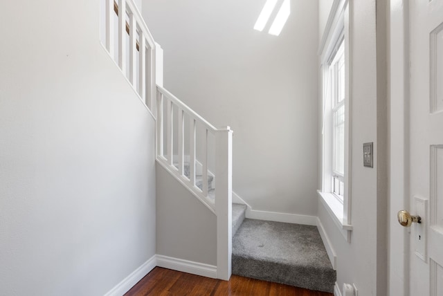 foyer entrance with plenty of natural light, stairway, dark wood-type flooring, and baseboards