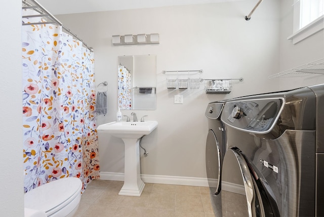 bathroom with washer / dryer, toilet, tile patterned flooring, and a shower with curtain