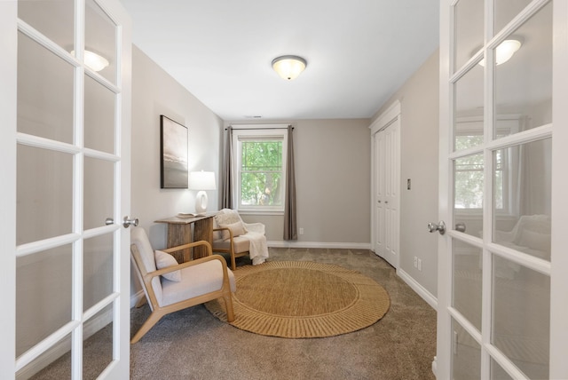 living area featuring french doors, carpet, and baseboards