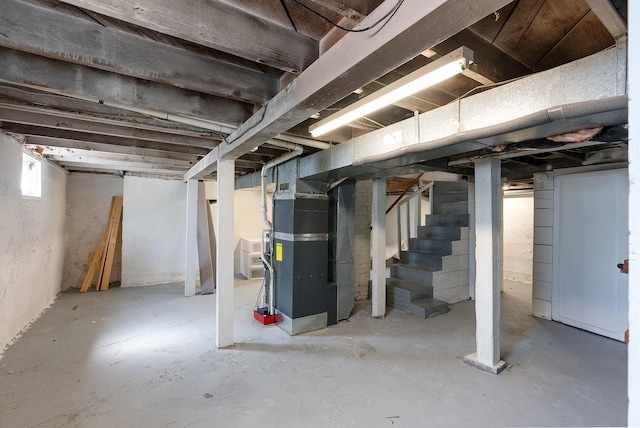 basement with stairway and heating unit