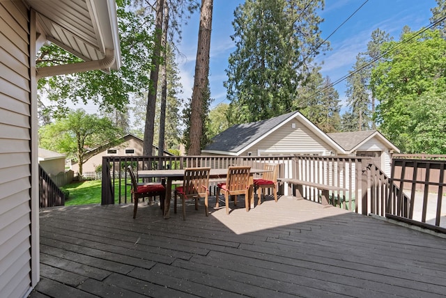 wooden deck featuring outdoor dining space and an outdoor structure