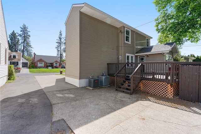 back of house featuring a wooden deck and cooling unit