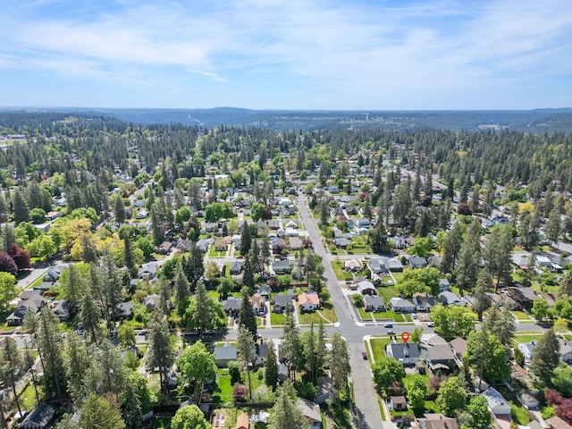 aerial overview of property's location with a heavily wooded area and nearby suburban area