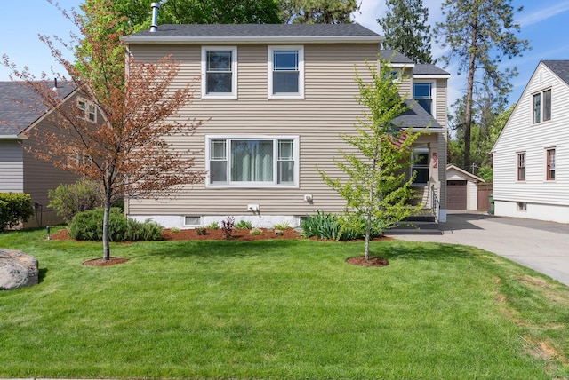 traditional-style home featuring an outbuilding, a front lawn, a detached garage, and roof with shingles