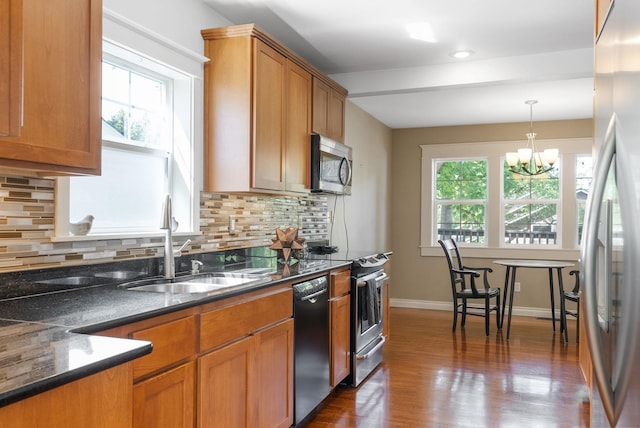 kitchen featuring stainless steel appliances, plenty of natural light, a chandelier, dark wood finished floors, and recessed lighting