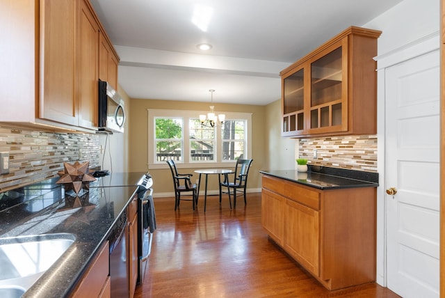 kitchen featuring stainless steel microwave, glass insert cabinets, backsplash, wood finished floors, and recessed lighting