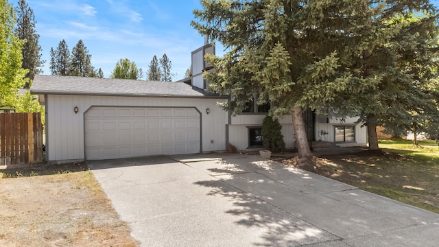 3326 E Pineglen Ave, Mead, WA 99021 - view of property hidden behind natural elements featuring a garage, concrete driveway, fence, a chimney, and roof with shingles
