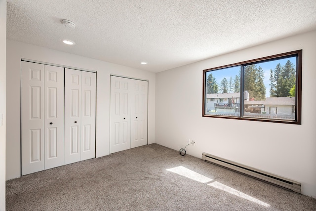 3326 E Pineglen Ave, Mead, WA 99021 - unfurnished bedroom featuring baseboard heating, two closets, carpet, a textured ceiling, and recessed lighting