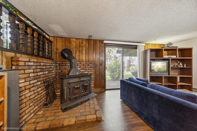 10511 E Cimmaron Dr, Spokane, WA 99206 - living room with a textured ceiling, a wood stove, wood finished floors, and wood walls