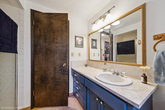 10511 E Cimmaron Dr, Spokane, WA 99206 - bathroom featuring vanity, decorative backsplash, and wood finished floors
