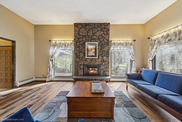 10511 E Cimmaron Dr, Spokane, WA 99206 - living area with a stone fireplace, wood finished floors, baseboard heating, and a textured ceiling