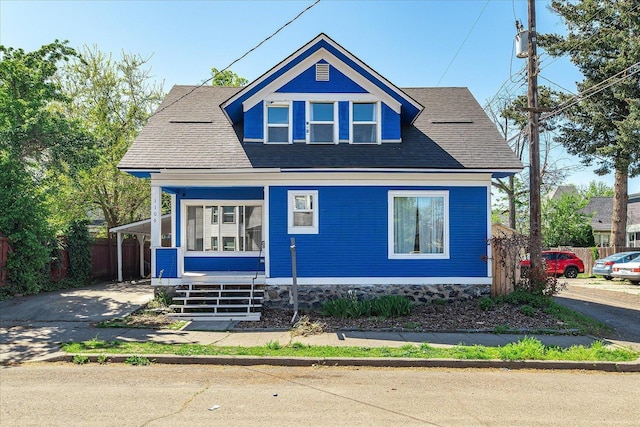 view of front of home with covered porch and fence