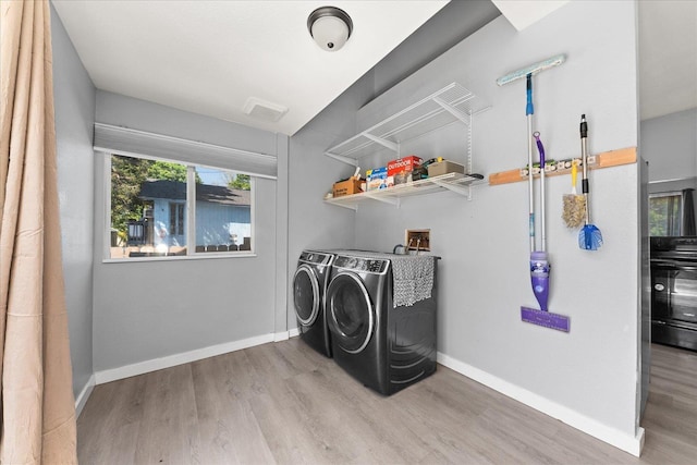 laundry room featuring washer and dryer, wood finished floors, and baseboards