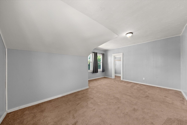 bonus room with carpet flooring, baseboards, and a textured ceiling