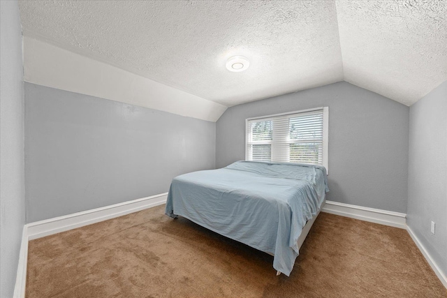 carpeted bedroom with lofted ceiling, a textured ceiling, and baseboards