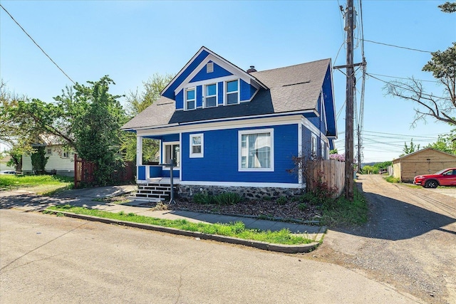 view of front of home featuring a porch, a shingled roof, and driveway