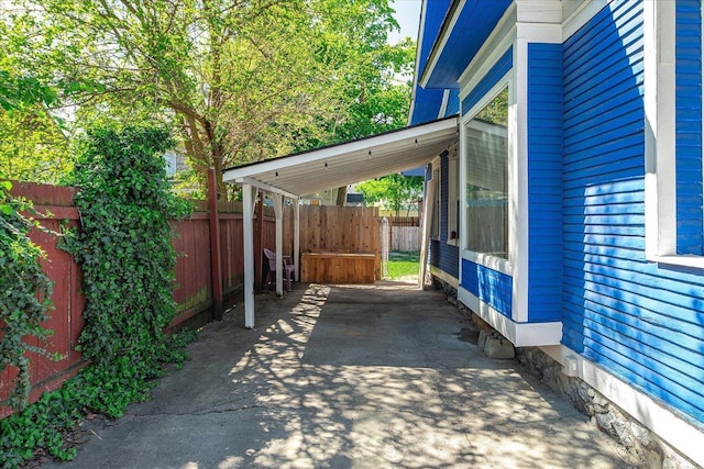view of patio / terrace with fence and a carport